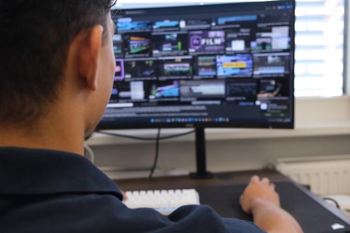 Blick über die Schulter auf einen Schnittplatz mit geöffnetem Videoprojekt