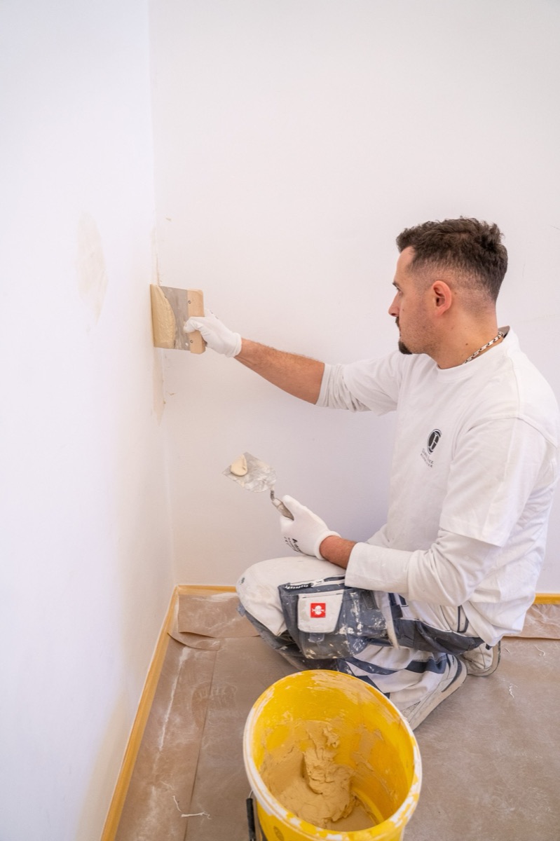 Maler spachtelt eine Wand
